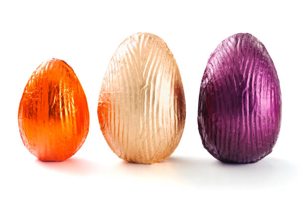 Three delicious chocolate easter eggs wraped in multicolored tinfoil, isolated