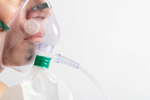 Lower part of a woman´s face with an oxygen mask. Copy space.