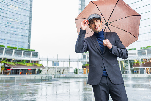 Annoyed Young Man with Umbrella Isolated on the White Background