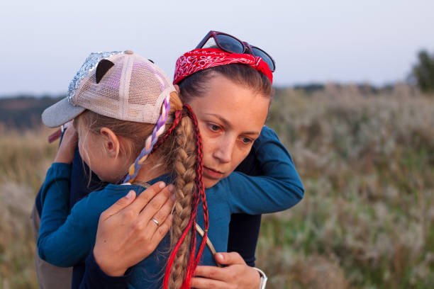 madre e figlia che si abbracciano sul paesaggio naturale. mamma con bambino che cammina la sera all'aperto. amore, cura, amicizia, - women crying sadness humor foto e immagini stock