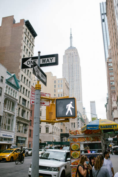 semáforo de pedestres em manhattan com empire state building ao fundo - one way stop stop sign street - fotografias e filmes do acervo