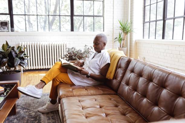 istock Senior woman reading book while spending a relaxing day at home 1339526757