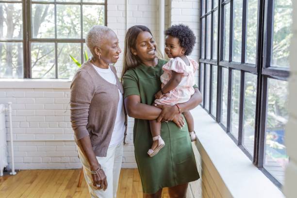 bambina carina che trascorre del tempo con sua madre e sua nonna a casa - senior adult independence lifestyles home interior foto e immagini stock