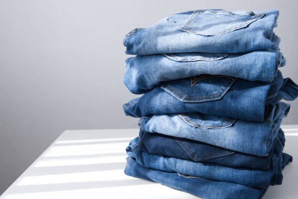 istock a pile of blue jeans on a light background. Close up. Copy space. Sunlight 1339527771