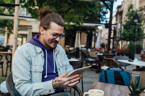 istock Portrait of a young man using tablet at the cafe 1339532600
