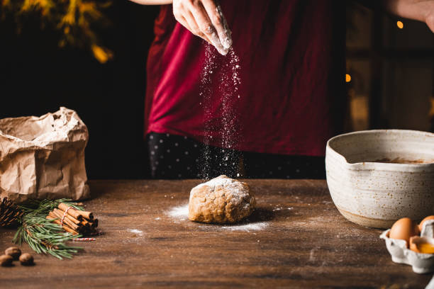 istock Woman sprinkling flour on cookie dough in kitchen 1339536374