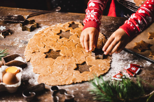 istock Boy's hand cutting dough with christmas star cookie cutter 1339536397