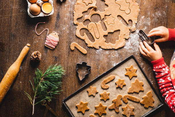 istock Young boy cutting dough to make christmas cookies in candy cane shape 1339536440