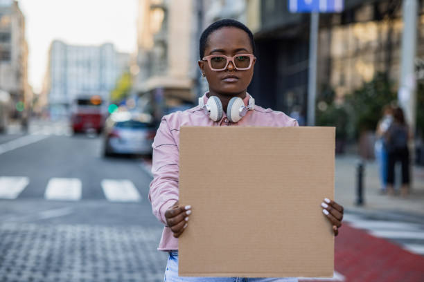 istock Young protester on the street holding blank sign 1339537632