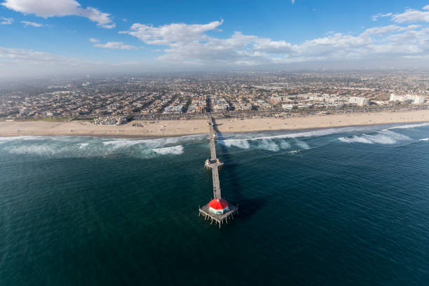 Huntington Beach Pier Aerial in Southern California Aerial view of popular Huntington Beach Pier in Southern California. huntington beach california stock pictures, royalty-free photos & images