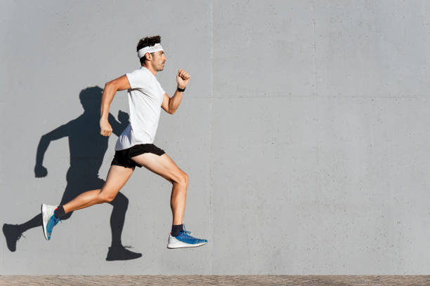istock Caucasian young man doing sport jumping, shadow cast on the wall 1339541818