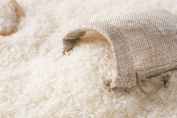 istock Dry white rice in sack background 1339542696