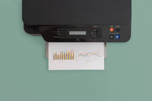 Photo of Printer on green background. Top view with copy space. Flat lay.