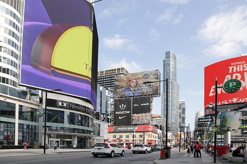 Toronto, Canada - August 26, 2021: Projection screens line Yonge Street between the Toronto Eaton Centre and Yonge-Dundas Square in the downtown district. View looking north on Yonge Street, a major retail district.