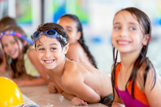 istock Smiling little boy during a group swimming lesson 1339552004
