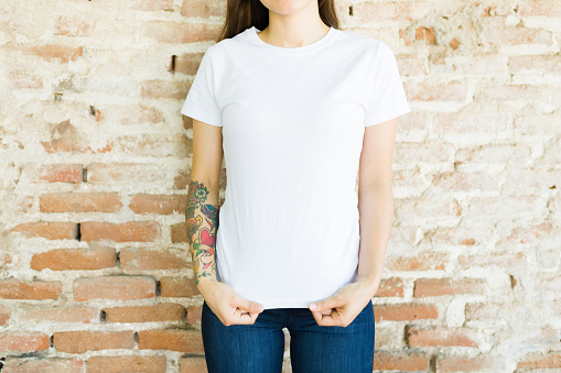 Look at this trendy print. Crop view of an hispanic young woman showing her white print t-shirt