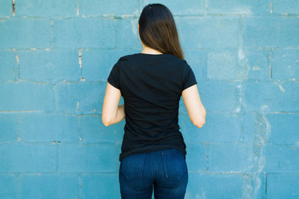Woman seen from behind with a print t-shirt stock photo