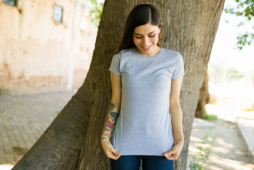Look at this beautiful design. Happy woman showing the print on her gray t-shirt