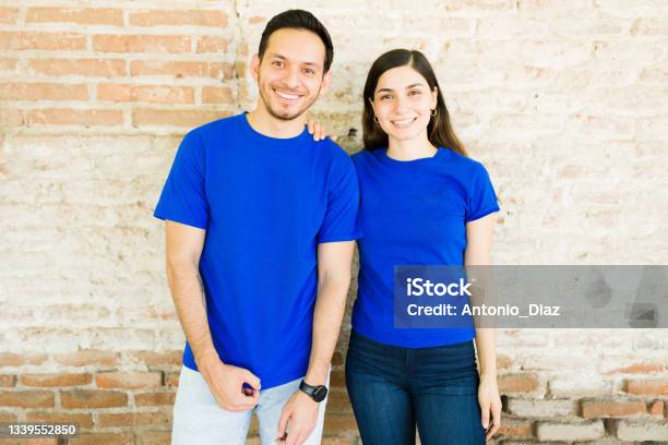 Portrait Of A Woman And Man With Mockup Tshirts Stock Photo - Download Image Now - Blue, Shirt, T-Shirt