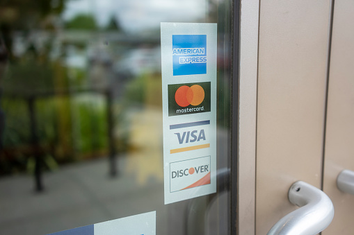 Beaverton, OR, USA - Sep 10, 2021: Payment options sticker is seen on a restaurant door in Beaverton. American Express, MasterCard, Visa, and Discover are the 4 major credit card networks in the US.