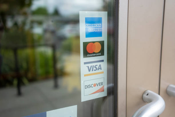 Amex, MasterCard, Visa, and Discover Beaverton, OR, USA - Sep 10, 2021: Payment options sticker is seen on a restaurant door in Beaverton. American Express, MasterCard, Visa, and Discover are the 4 major credit card networks in the US. american express stock pictures, royalty-free photos & images