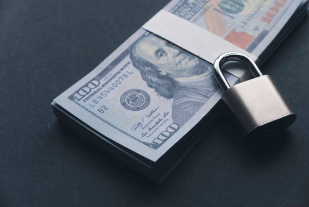 istock Selective focus of a padlock on a money on a black background 1339564171