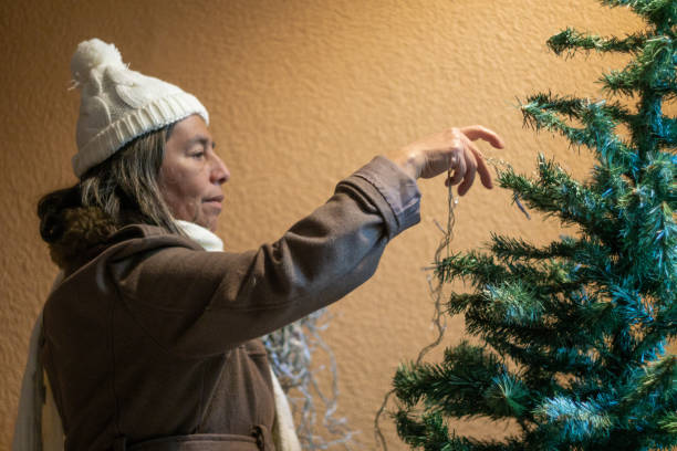 istock beautiful old woman decorates the christmas tree 1339567691
