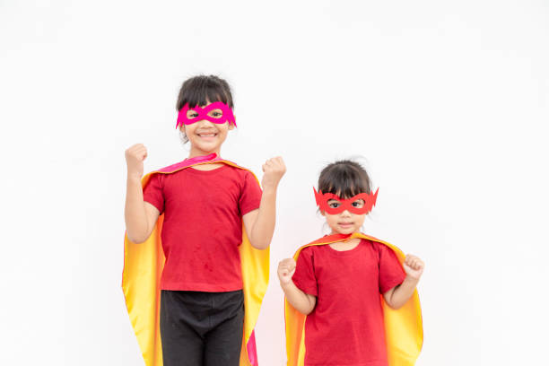 istock Two girls in a superhero costume on white background 1339571004