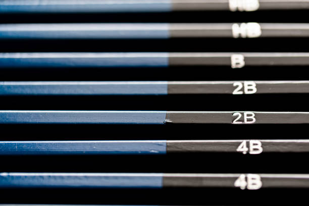 Selective focus on 2B pencil on full set of black and blue writing and drawing graphite pencils sorting from dark to light.