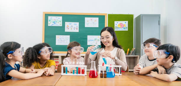 diversity children doing a chemical experiment in laboratory at school. portrait of happy kids at elementary school learning science chemistry with asian teacher. fun study back to school banner - medical exam science research scientific experiment imagens e fotografias de stock