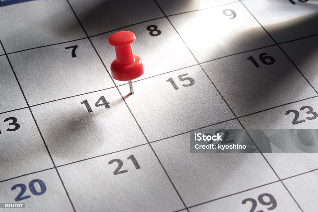 Красный pushpin в календарь с лучи света - Стоковые фото Календарь роялти-фри