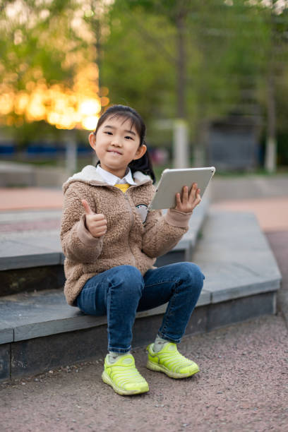 little girl holding ipad e-learning - american sign language student learning real people fotografías e imágenes de stock