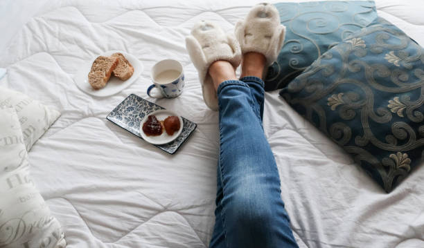 взгляд человека женщины в уютных синих тапочках, отдыхающих дома - slipper senior adult shoe human leg стоковые фото и изображения