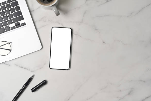 istock Mock up smart phone, laptop computer and coffee cup on marble background. 1339586127