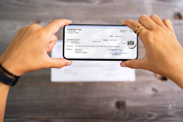 Remote Check Deposit Taking Photo With Phone Remote Check Deposit Taking Photo With Mobile Phone bank deposit slip photos stock pictures, royalty-free photos & images