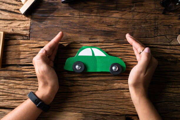 istock Hand Protecting Green Toy Car 1339597812