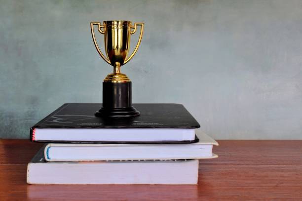 Gold cup trophy and books stock photo