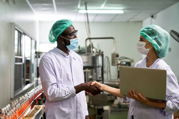 istock African and Caucasian Lab Specialist shake hand for cooperation 1339602989