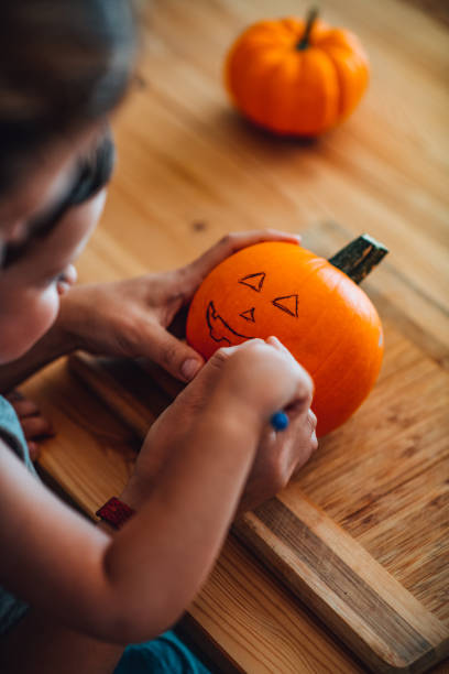 istock Mother and Son Making Jack-o'-Lantern 1339603468