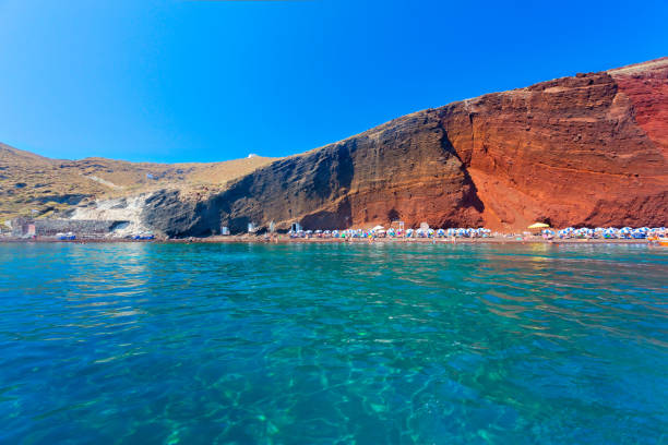 The long Vlychada Beach of Santorini with its impressive pumice cliffs during sunset.