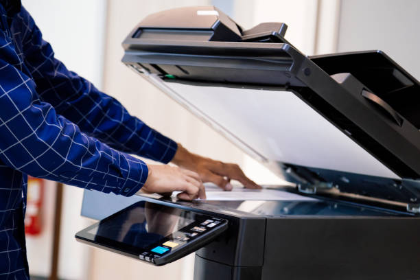 istock Businessmen press button on the panel for using photocopier or printer for printout and scanning document paper at office. 1339613773