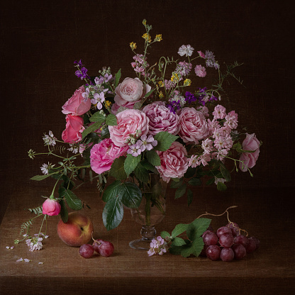 Still life with pink roses and autumn ripe fruits on dark background, for posters