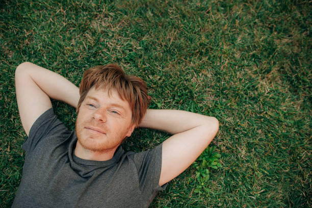 istock Portrait of positive man resting on grass 1339618746