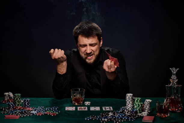 istock Bearded casino player man playing poker on green table 1339619378