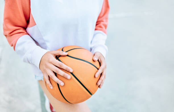 Close-up of a basketball with space for copy Close-up of an unrecognizable girl with a basketball. asphalt basketball court stock pictures, royalty-free photos & images