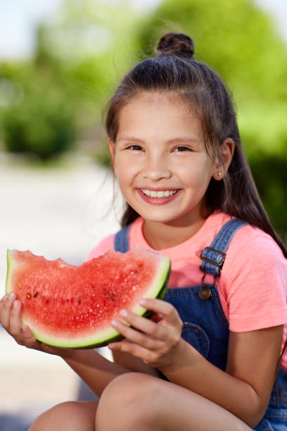 istock child girl eats a watermelon in sunny day 1339621745