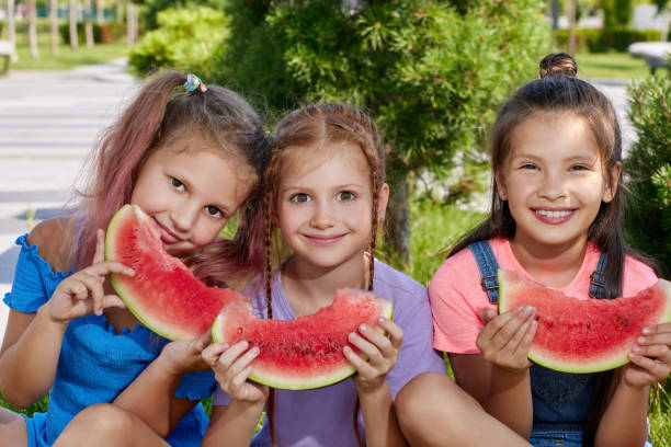 istock child girl eats a watermelon in sunny day 1339622166