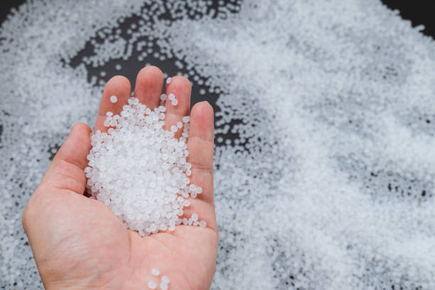 istock White plastic beads on wood  background, Polymers bead or polymer resin, polymer pallet, Product from petrochemical plants. granules polymer, 1339625996