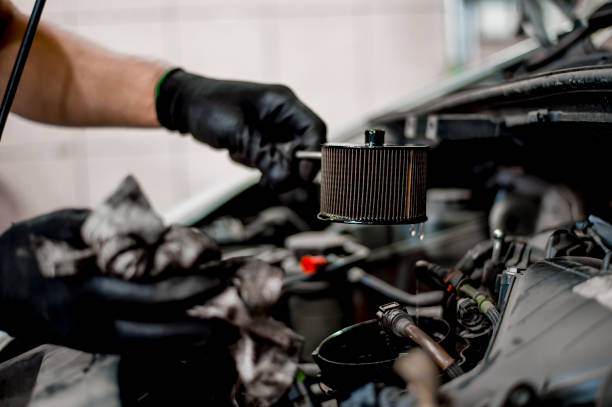 Auto mechanic working on car engine in mechanics garage