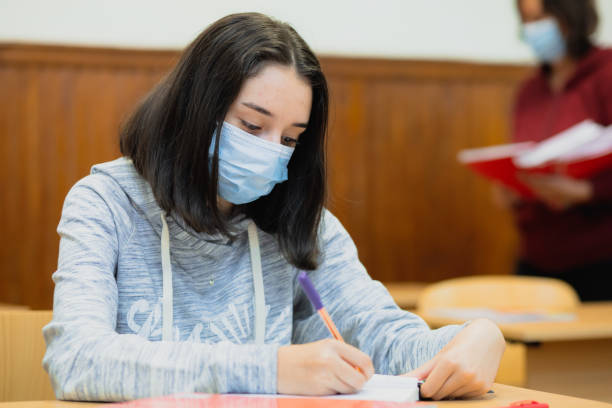 istock Female high school student in classroom wearing protective face mask 1339626387